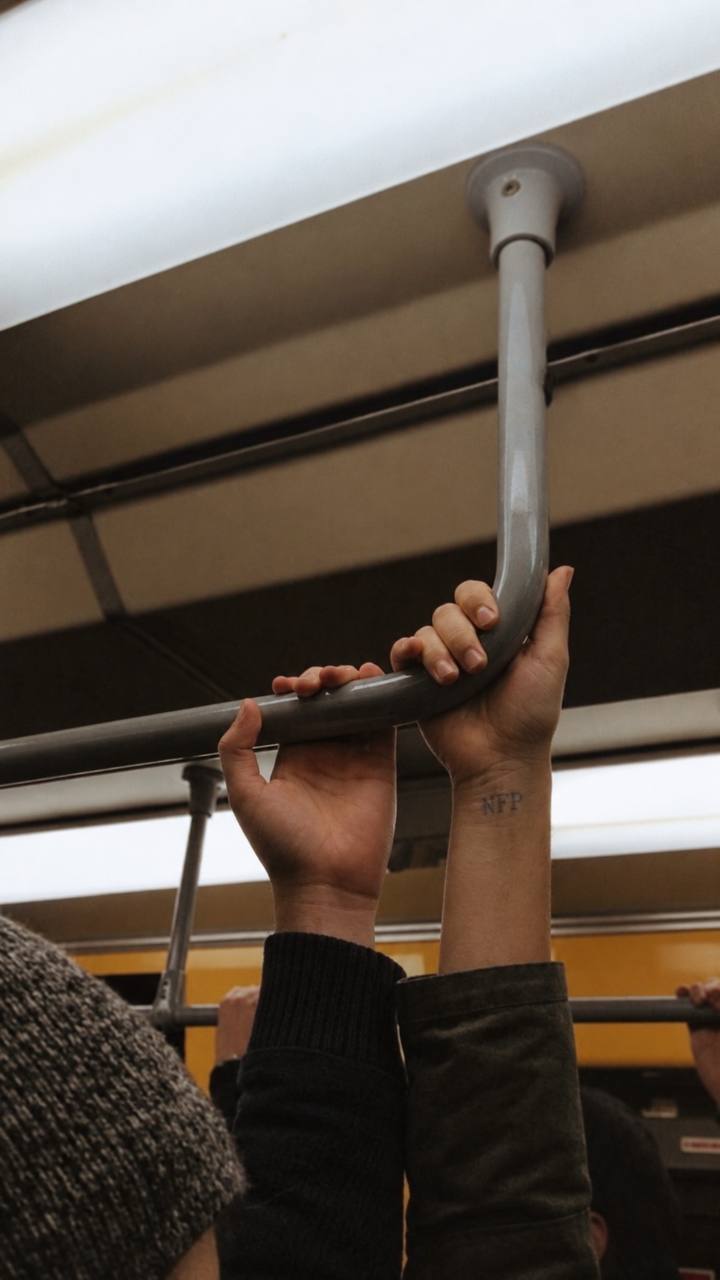 Hands holding a subway rail